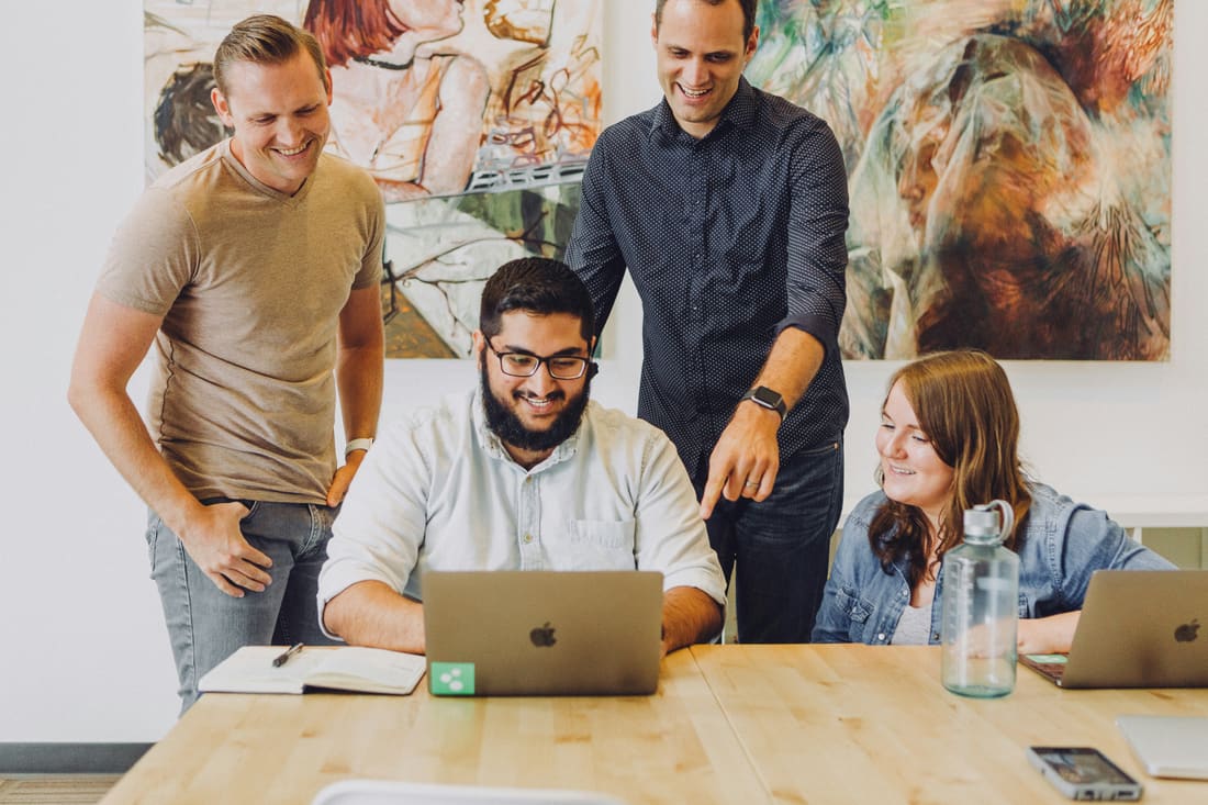 A growing team working together around a laptop